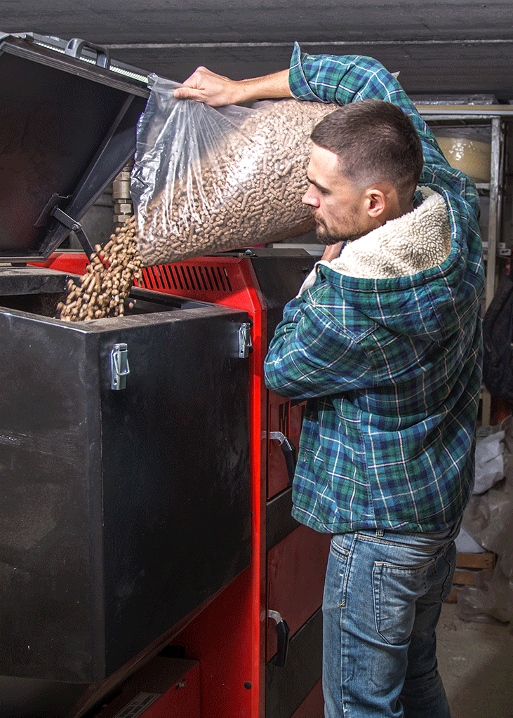 Un hombre echando pellets en un tanque de combustible